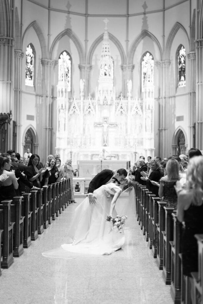 catholic couple married in large church kissing